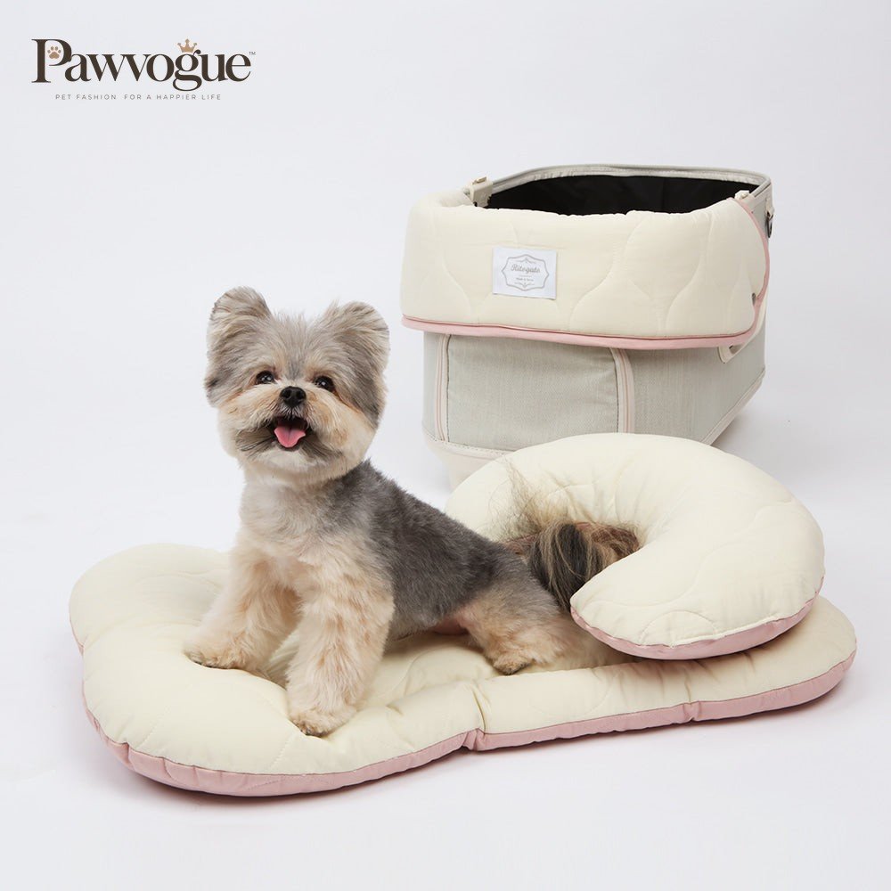 Small dog sitting on a beige stroller liner with a matching pet carrier on a white background